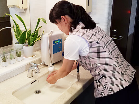 手洗い場に設置されたハイジョキンⅡで手を洗うスタッフ